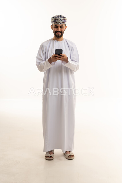Omani Man in Traditional Dress Using Smartphone