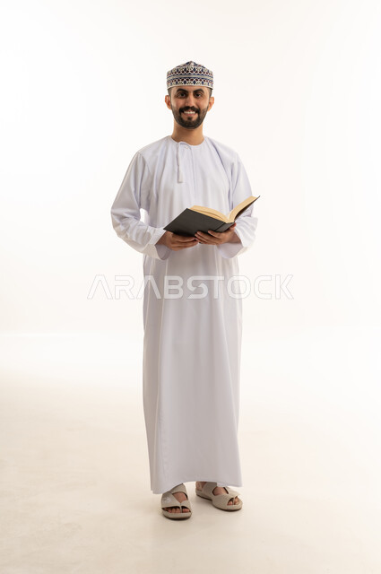 Omani Man in Traditional Dress Holding Book White Background