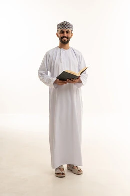 رجل عُماني بالزي التقليدي يحمل كتاباً على خلفية بيضاء