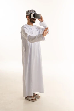 رجل عُماني يرتدي نظارة واقع افتراضي في استوديو