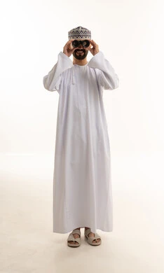 رجل عماني بالزي التقليدي يستخدم المنظار