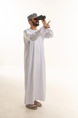 رجل عماني يستخدم المنظار على خلفية بيضاء