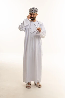 رجل عماني بالزي التقليدي يفرك عينه في الاستوديو