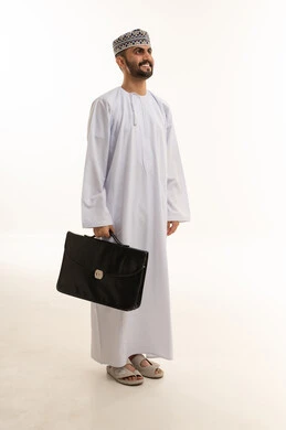 رجل أعمال عماني بالزي التقليدي يحمل حقيبة عمل