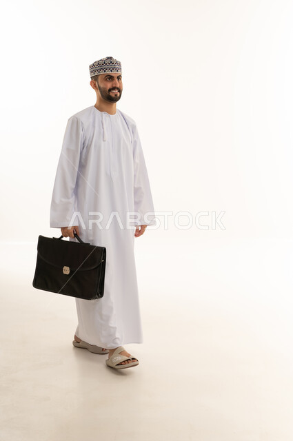 رجل أعمال عماني يحمل حقيبة عمل على خلفية بيضاء
