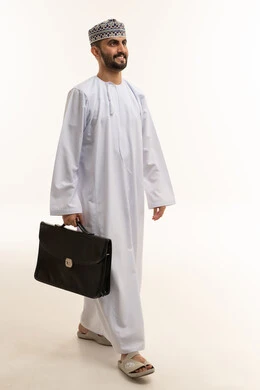 رجل أعمال عماني يمشي مع حقيبة عمل في الاستوديو