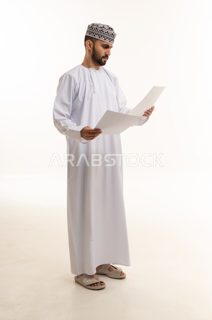 Omani Man Reading Documents in Traditional Dress