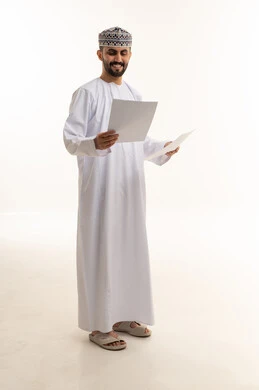 رجل عماني بالزي التقليدي يحمل أوراقاً رسمية