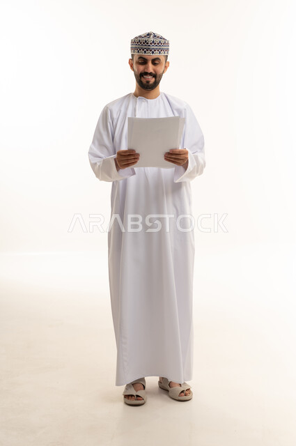 Omani Man in Traditional Dress Holding Documents