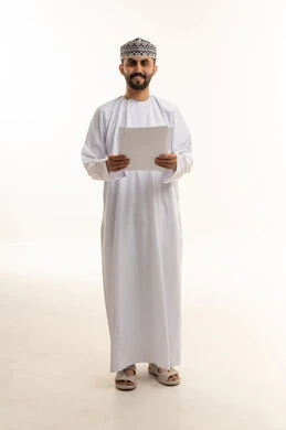 رجل عماني بالزي التقليدي يحمل أوراق رسمية