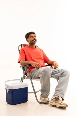 رجل عربي على كرسي تخييم مع صندوق تبريد