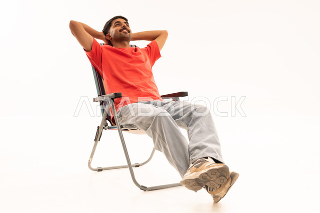Saudi Man Relaxing on Folding Chair White Background
