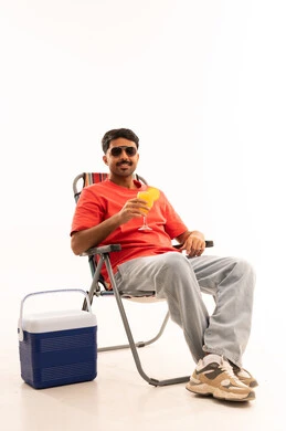 رجل سعودي يجلس على كرسي تخييم مع صندوق تبريد