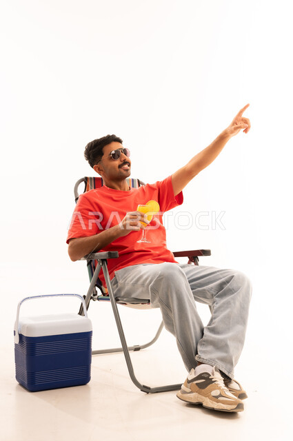 Saudi Man Relaxing in Folding Chair with Cooler