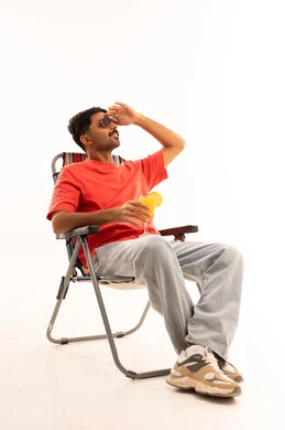 رجل سعودي على كرسي الشاطئ مع عصير خلفية بيضاء