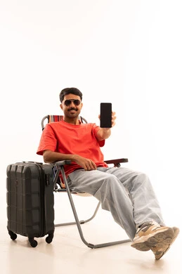 رجل مع حقيبة سفر يحمل هاتفاً ذكياً