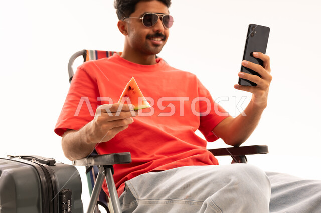Saudi Man with Smartphone and Watermelon Travel Concept