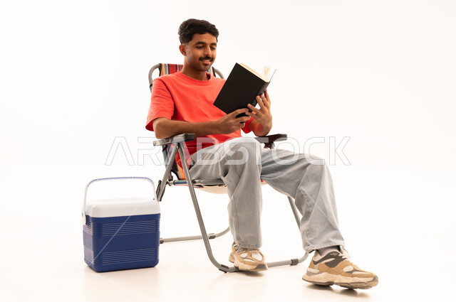 شاب سعودي يقرأ كتاباً على كرسي رحلات