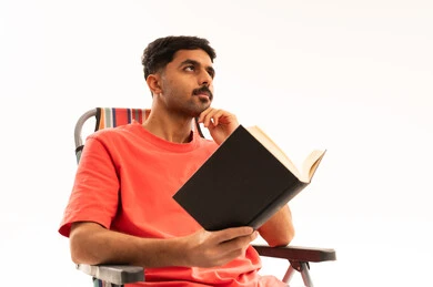 شاب عربي يقرأ كتاباً على خلفية بيضاء