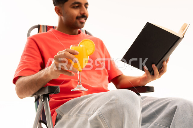 Saudi Man Reading Book with Orange Juice