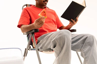 رجل يقرأ كتاباً ويتناول البطيخ في الاستوديو