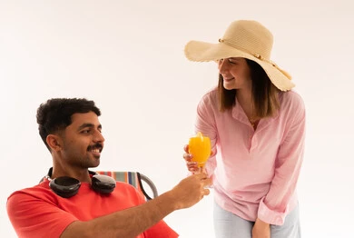 رجل وامرأة مع عصير برتقال على كرسي الشاطئ