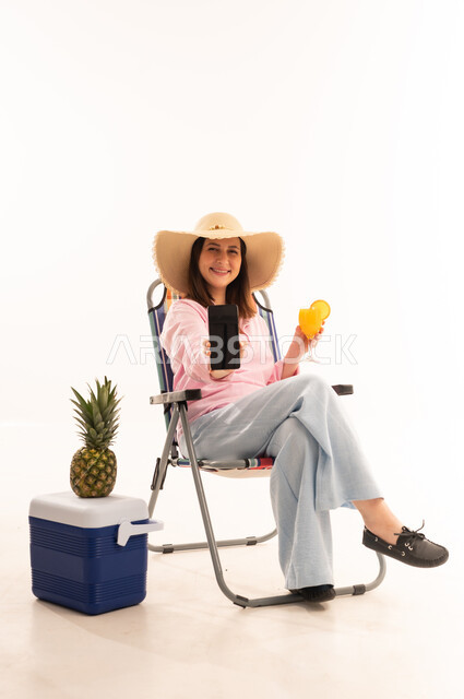 Woman on Beach Chair Holding Smartphone and Juice