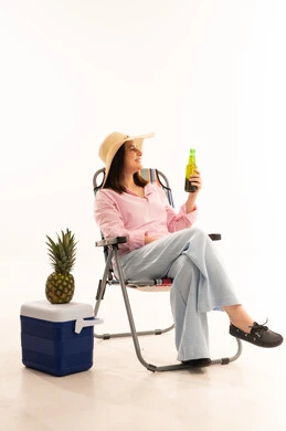 Woman in Camping Chair with Beverage in Studio