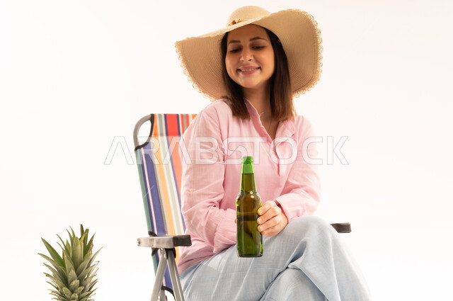 Arab Woman Sitting on Beach Chair with Beverage