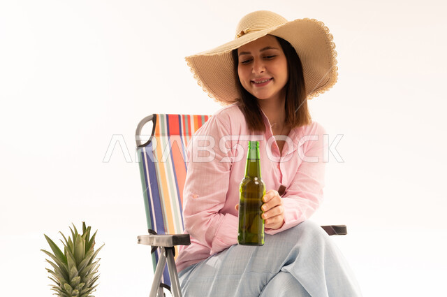 Arab Woman with Sun Hat and Beach Chair in Studio