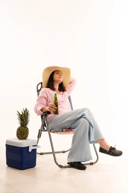 Woman Relaxing in Beach Chair with Cooler and Pineapple