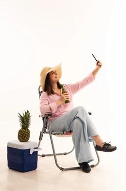 Woman with Straw Hat Taking Selfie in Beach Chair