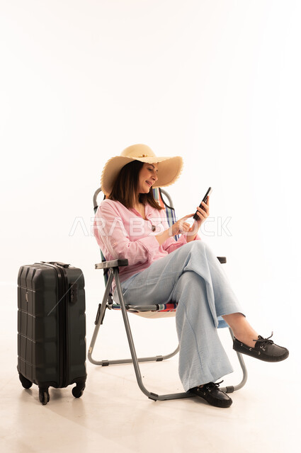 Arab Woman Traveler Using Smartphone with Suitcase