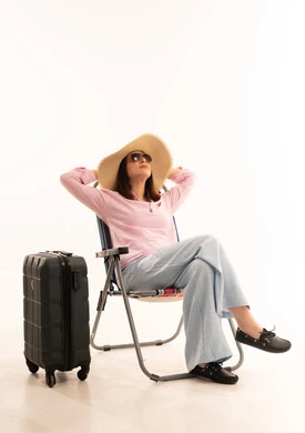 امرأة عربية مسافرة تسترخي بجانب حقيبة السفر