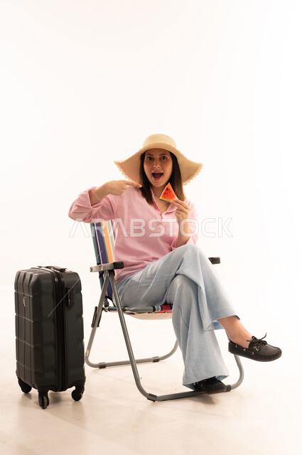 امرأة عربية مسافرة مع حقيبة سفر وبطيخ