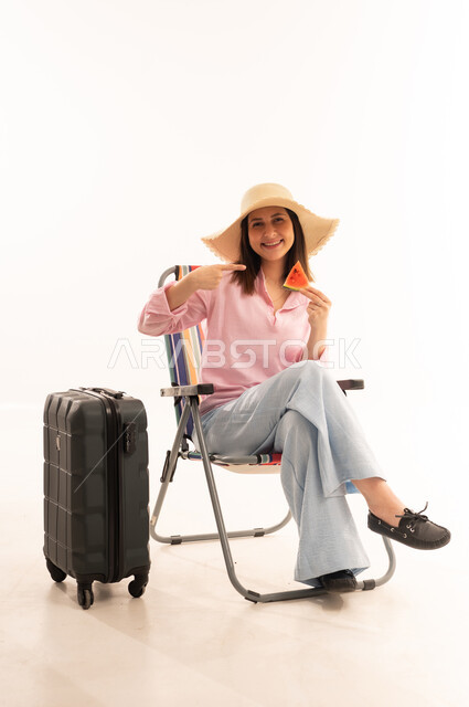 Woman Traveler with Suitcase and Watermelon in Studio