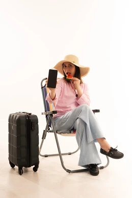 امرأة عربية مسافرة مع هاتف ذكي وحقيبة سفر