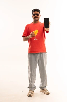 رجل يحمل هاتف ذكي وعصير برتقال بخلفية بيضاء