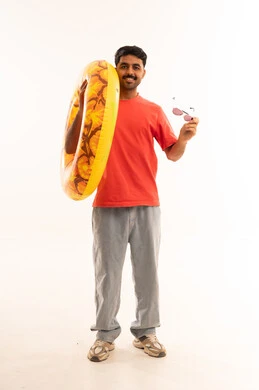 رجل سعودي يحمل طوق سباحة ونظارات شمسية