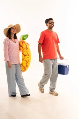 زوجان عربيان مع مستلزمات الشاطئ على خلفية بيضاء