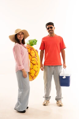 زوجان عربيان مع مستلزمات الشاطئ على خلفية بيضاء