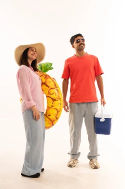 زوجان سعوديان مع أدوات الشاطئ الصيفية خلفية بيضاء