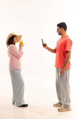 رجل سعودي يصور امرأة في استوديو بخلفية بيضاء