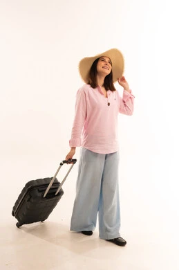 امرأة تمشي مع حقيبة سفر على خلفية بيضاء