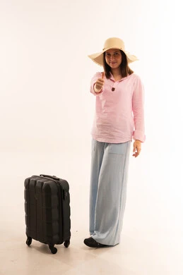 امرأة مسافرة مع حقيبة سفر وإشارة الإبهام