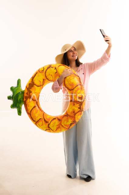Woman with Pineapple Inflatable Ring Taking Selfie