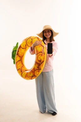 Woman with Pineapple Swimming Ring Holding Smartphone