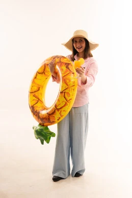 امرأة عربية مع طوق سباحة أناناس وعصير