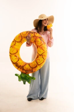 امرأة عربية مع عوامة أناناس وقبعة صيفية