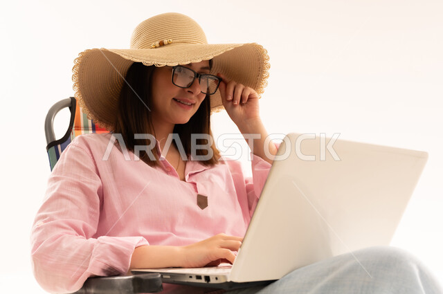 Arab Woman Using Laptop Wearing Straw Sun Hat